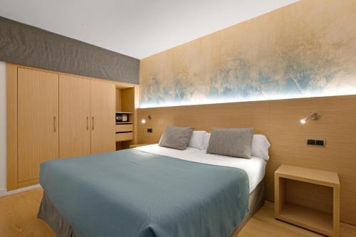 a bedroom with a bed with a blue blanket at Aparthotel Fontanellas Playa in Playa de Palma