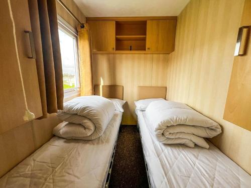 Tunstall的住宿－Lovely Caravan At Sand Le Mere Holiday Park In Yorkshire Ref 71110td，小型客房 - 带2张床和窗户