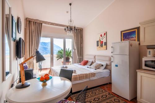 a bedroom with a bed and a table and a refrigerator at Mila & Aleksandr Apartments in Budva
