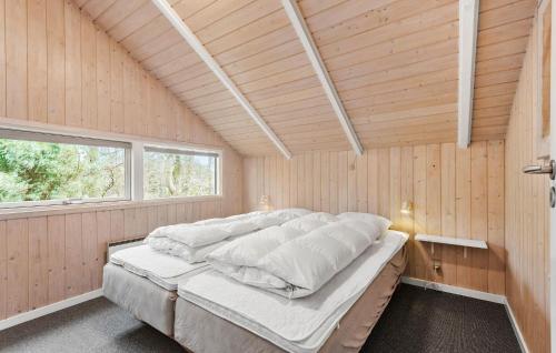 OksbølにあるCozy Home In Oksbl With Wifiの木製の壁の客室の大型ベッド1台