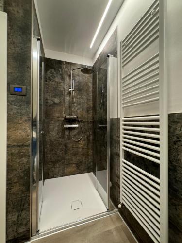 una ducha con puerta de cristal en un baño en San Rocco Apartments 2, en Riva del Garda