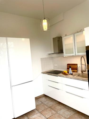 a kitchen with white cabinets and a sink at Seeliebe, 300 Meter zum Wasser, mit Terrasse und Garten in Lembruch