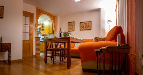 sala de estar con mesa y sofá en Dúplex FAJALAUZA ALBAICÍN, en Granada