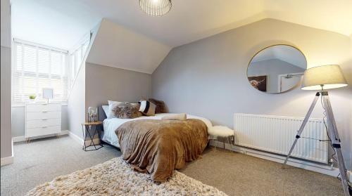 um quarto com uma cama e um espelho na parede em Castle Boulevard Nottingham - 5 Beds Home - Long stays welcome for families, professionals & contractors em Nottingham