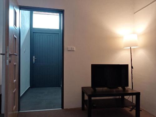 a room with a door and a television on a table at Apartmán Nepomuk in Nepomuk