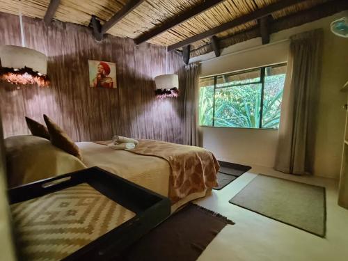 a bedroom with a large bed and a window at Shangrila-innibos Country Lodge in Hartbeespoort