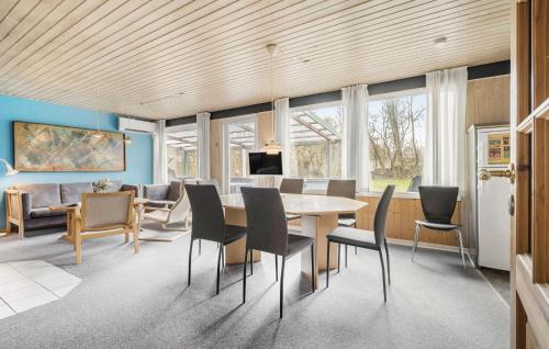 a dining room and living room with a table and chairs at Four-Bedroom Holiday Home In Hemmet in Hemmet