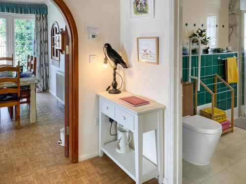 a bird sitting on a table in a bathroom at Walnut Cottage in Long Melford