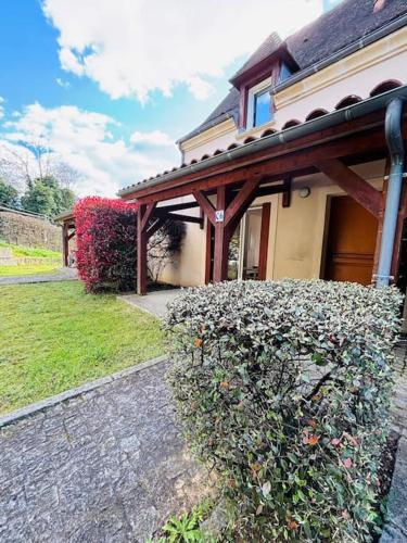 une maison avec une haie devant un bâtiment dans l'établissement Appart*Parking*Résidence Piscine*Sarlat, à Sarlat-la-Canéda