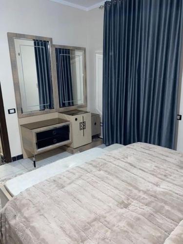 una camera con letto, cassettiera e specchio di شقة فندقية للايجار a Il Cairo