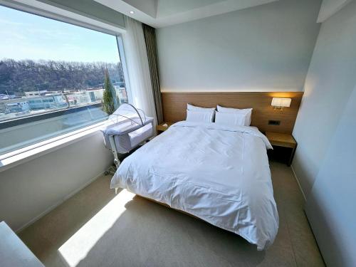 1 dormitorio con cama y ventana grande en Gran Hotel en Gunsan