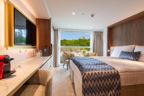 una habitación de hotel con una cama grande y un comedor en Thurgau Gold - Art Basel Riverboat Hotel I, en Basilea