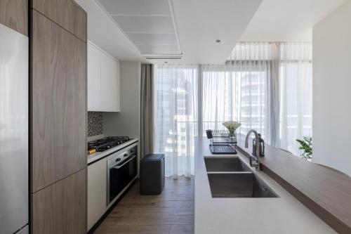 uma cozinha com um lavatório e um fogão em 2BR apartment in Jumeirah Living Marina Gate em Dubai