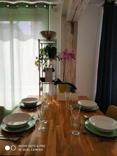 une table en bois avec des assiettes et des verres au-dessus dans l'établissement 2 min walk from train station and center of Tours, à Tours