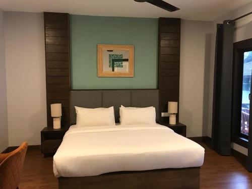 Un dormitorio con una gran cama blanca y una ventana en Perhentian Island Resort en Perhentian Island