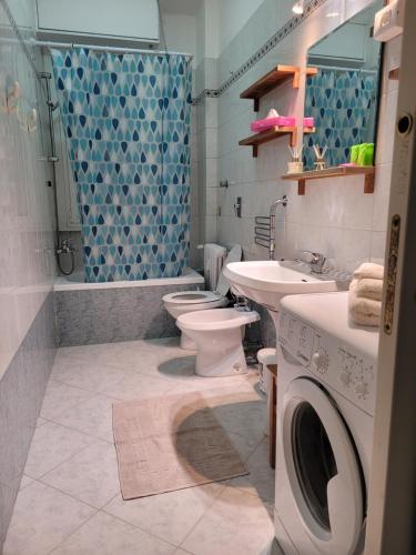 y baño con 2 aseos, lavamanos y lavadora. en FAMILY, en San Giuliano Milanese