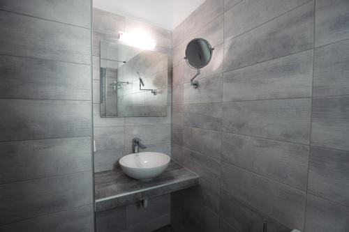 a bathroom with a sink and a mirror at Hotel Marybill in Perissa