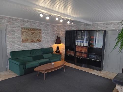 een woonkamer met een groene bank en een salontafel bij Maison au bord de l'eau et au calme pour les vacances in Saint-Denis-de-Pile