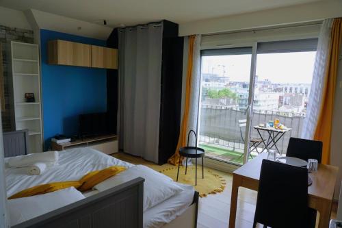 une chambre avec un lit et une grande fenêtre dans l'établissement Les Maisons Acajou - Ivry-sur-Seine, à Ivry-sur-Seine