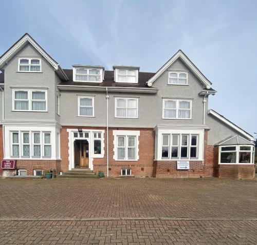 a large house with a red brick at The Lawn Hotel in Reading