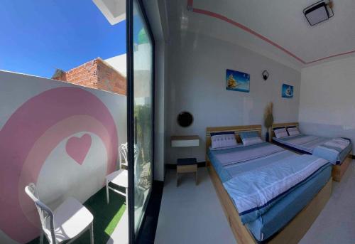 a bedroom with two beds and a glass window at Pink Sea Villa in Cu Lao Thu