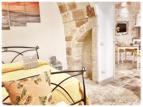 a bedroom with a bed and a stone fireplace at Antica Pietra in Polignano a Mare