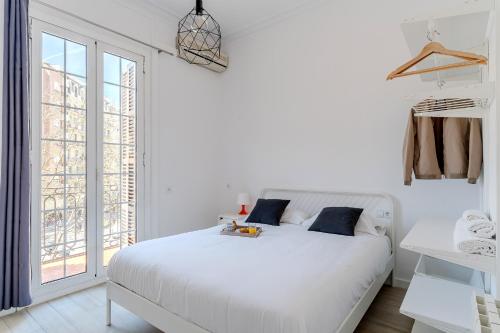 バルセロナにあるAB Calabria Apartmentの白いベッドルーム(白いベッド1台、窓付)