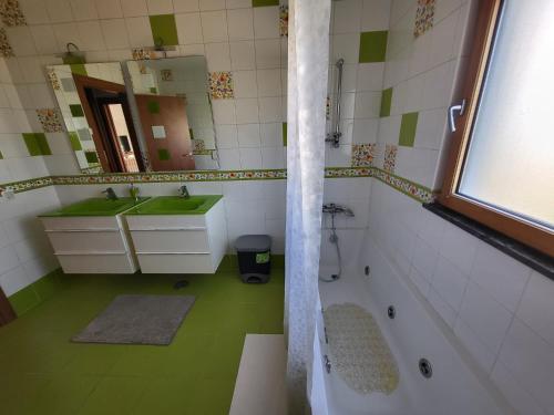 a bathroom with a sink and a tub and a mirror at AL "Villa Por Do Sol" Sunset Olhão in Olhão