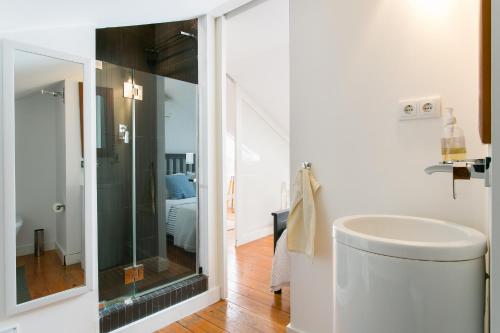 uma casa de banho com um lavatório e uma cabina de duche em vidro. em Loft Bairro Alto em Lisboa
