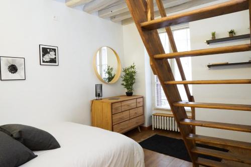 a bedroom with a bed and a wooden spiral staircase at EXIGEHOME - Ici habita Voltaire-Maison en plein centre-ville in Saint-Germain-en-Laye