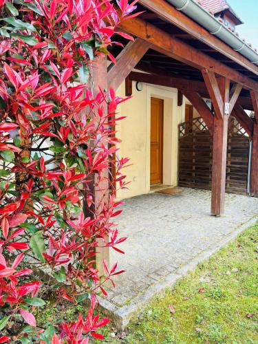 une maison avec une brousse rouge devant elle dans l'établissement Appart*Parking*Résidence Piscine*Sarlat, à Sarlat-la-Canéda