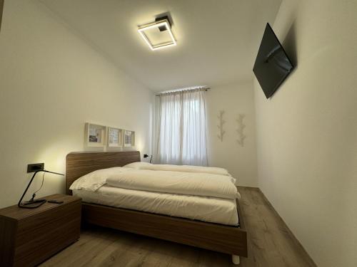 Un dormitorio con una cama y un televisor en la pared. en San Rocco Apartments 2, en Riva del Garda