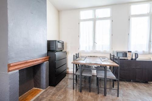 une cuisine avec une table et des chaises dans une pièce dans l'établissement La Serpe du Vieux Tours, à Tours