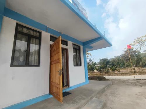 a small house with a blue trim and a door at EVELENA Guest House in Cherrapunji