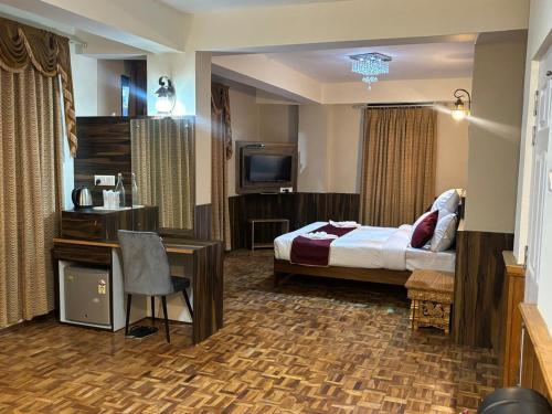 a hotel room with a bed and a desk and a television at CHANGU CHE RETREAT in Pelling