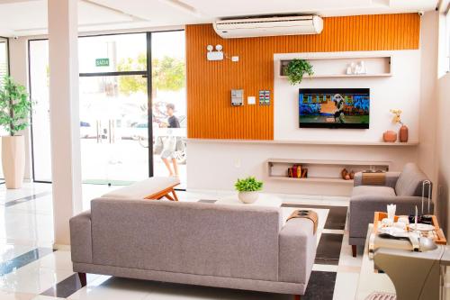 a living room with a couch and a tv at Citi Executivo Hotel in Parnaíba