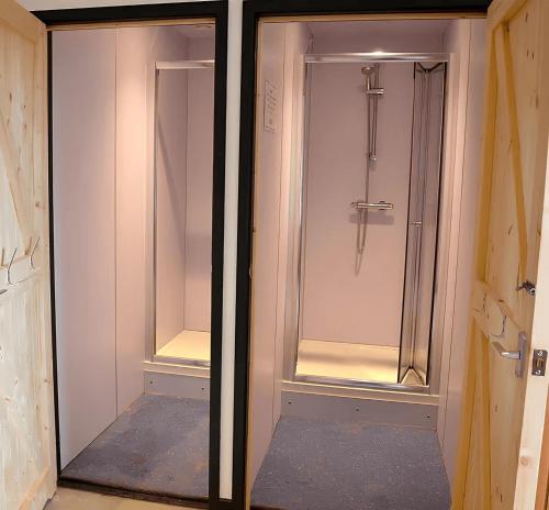 La salle de bains est pourvue d'une douche à l'italienne et de portes en verre. dans l'établissement Adventure Lodges and Retreats, à Bideford