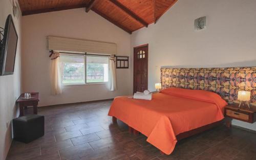 1 dormitorio con cama roja y ventana en Las Palmas en Mercedes