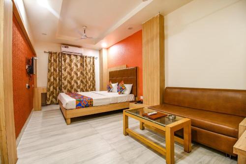 Habitación de hotel con cama y sofá en FabHotel The Oasis en Bhopal