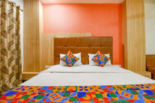 a bedroom with a large bed with a colorful bedspread at FabHotel The Oasis in Bhopal