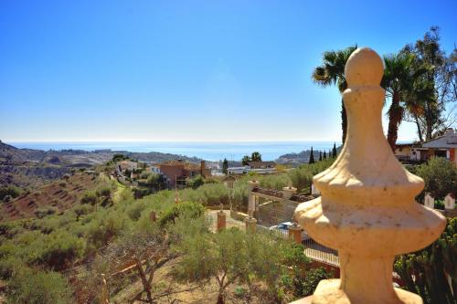 a statue of a bird standing on top of a hill at Villa rural en Málaga con piscina y vistas al mar in Málaga