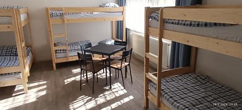 a room with bunk beds and a table and chairs at A Plus Hostel - Centrum in Prague