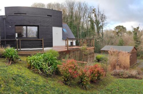 ein schwarzweißes Haus in einem Garten in der Unterkunft Superbe Villa d'architecte à 2 pas de la mer in Clohars-Carnoët