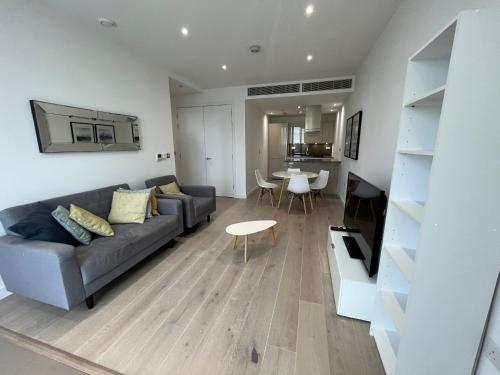 a living room with a couch and a table at 1 Bedroom Apartment Stratford in London