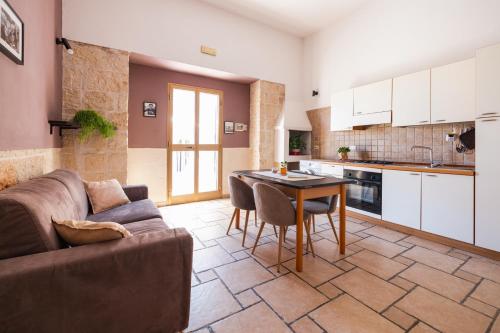 ein Wohnzimmer mit einem Sofa und einem Tisch in der Unterkunft CASA LAPILLI in Polignano a Mare