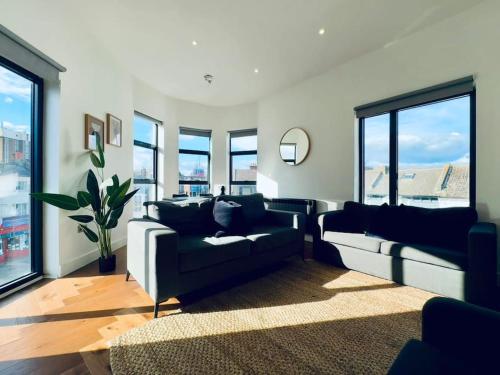 a living room with two couches and large windows at Amazing 2 Bedrooms I Brighton station I Sleep 6 in Brighton & Hove