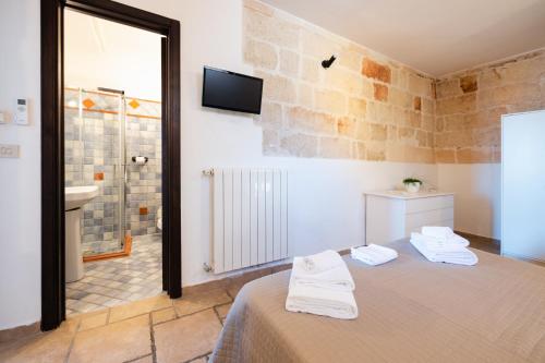 une chambre avec un lit et une salle de bain avec un lavabo dans l'établissement CASA LAPILLI, à Polignano a Mare