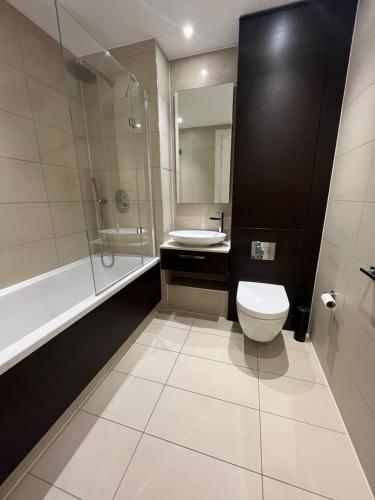 a bathroom with a toilet and a sink and a shower at 1 Bedroom Apartment Stratford in London