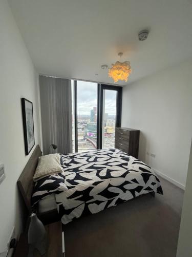sypialnia z czarno-białym łóżkiem i oknem w obiekcie 1 Bedroom Apartment Stratford w Londynie