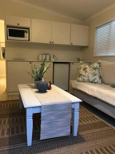 a living room with a table and a couch at Lazy Days in Natureʼs Valley